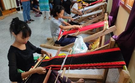 Girls learning traditional weaving on looms during skill development training